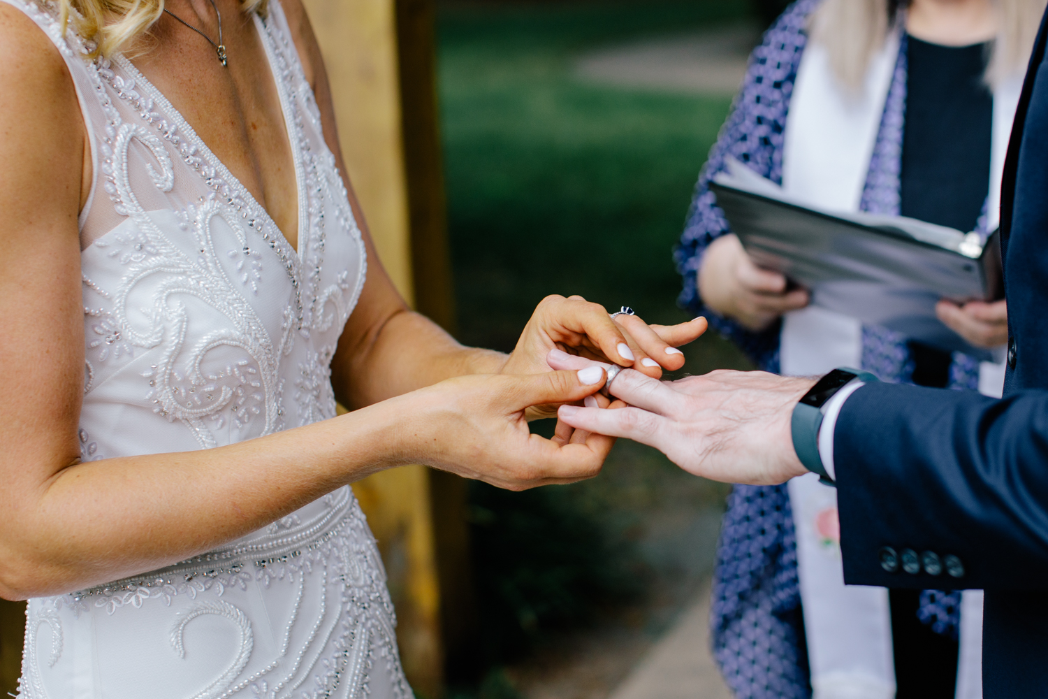 Bride putting on wedding band on her husbands finger at Charlotte NC elopement.