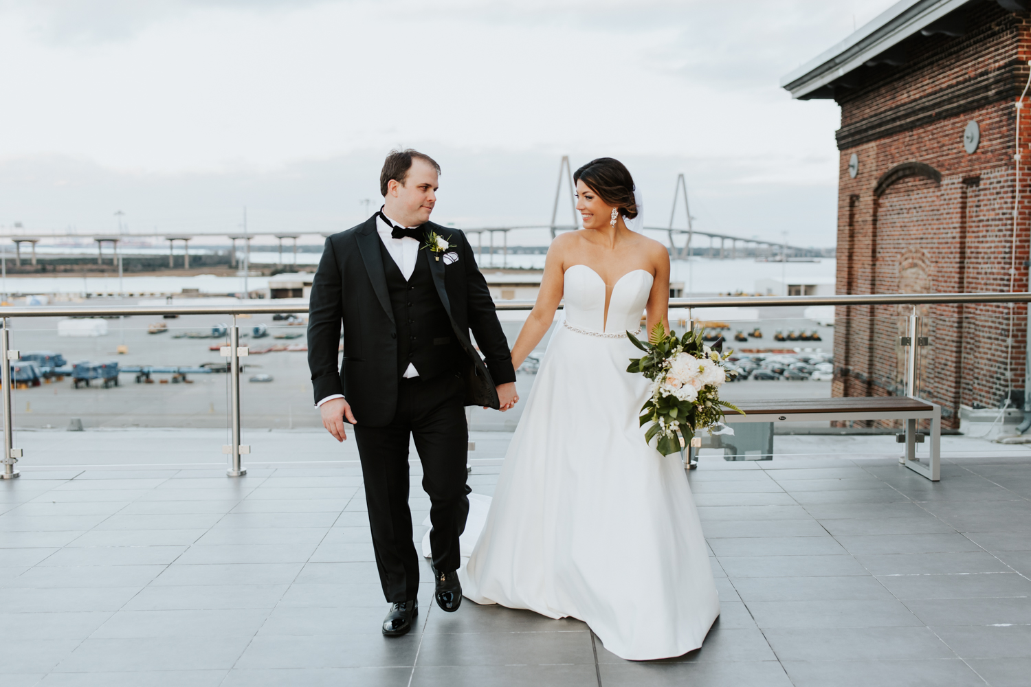 Bride and groom walking on the Cedar Room Wedding Venue rooftop. Wedding photographed byCharleston Wedding Photographer