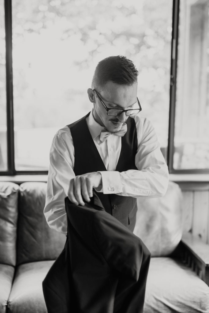Groom putting on jacket at Carolina Country weddings venue in Charlotte.