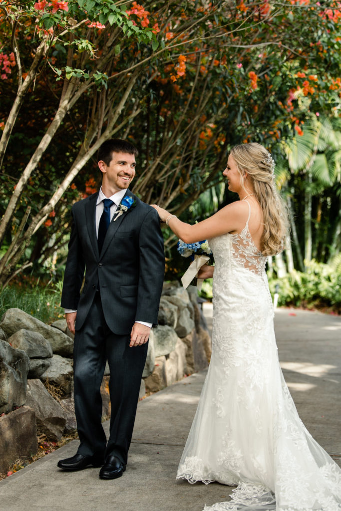 Bride, in white lace dress, seeing her groom, in a black suit, for the first time at the St. Lucia Grande Sandals Resort. Photographed by Charlotte wedding photographer.