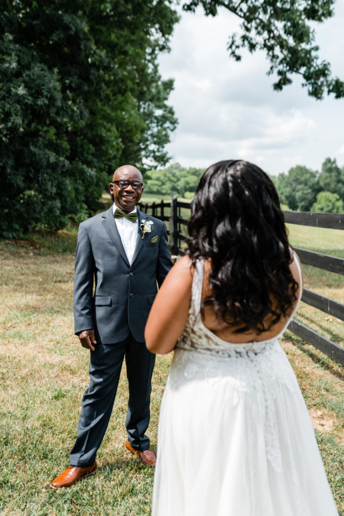 Bride, in white lace dress, seeing her dad for the first time at Carolina Country weddings venue in Charlotte.