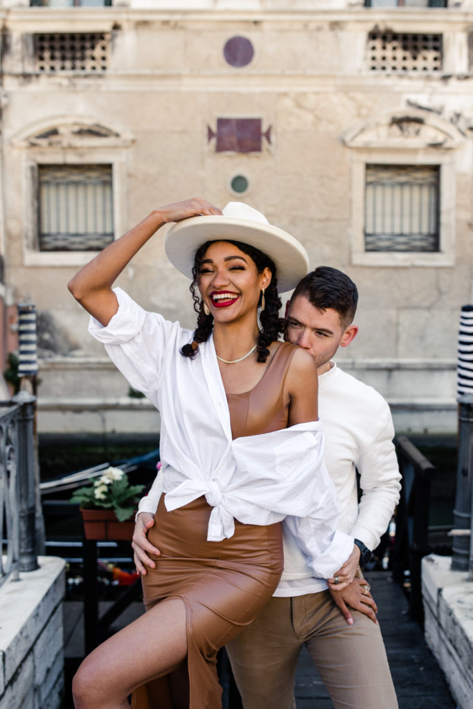 Girl, in brown leather dress and white button down, with boy, in white shirt and brown leather jacket, in Venice Italy. Photographed by Charlotte wedding photographer.