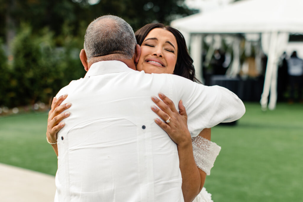 Bride, in white lace dress and veil, seeing her dad, in white shirt and black pants, for the first time at The Highlawn Wedding venue in New Jersey. Photographed by Charlotte Wedding photographer.