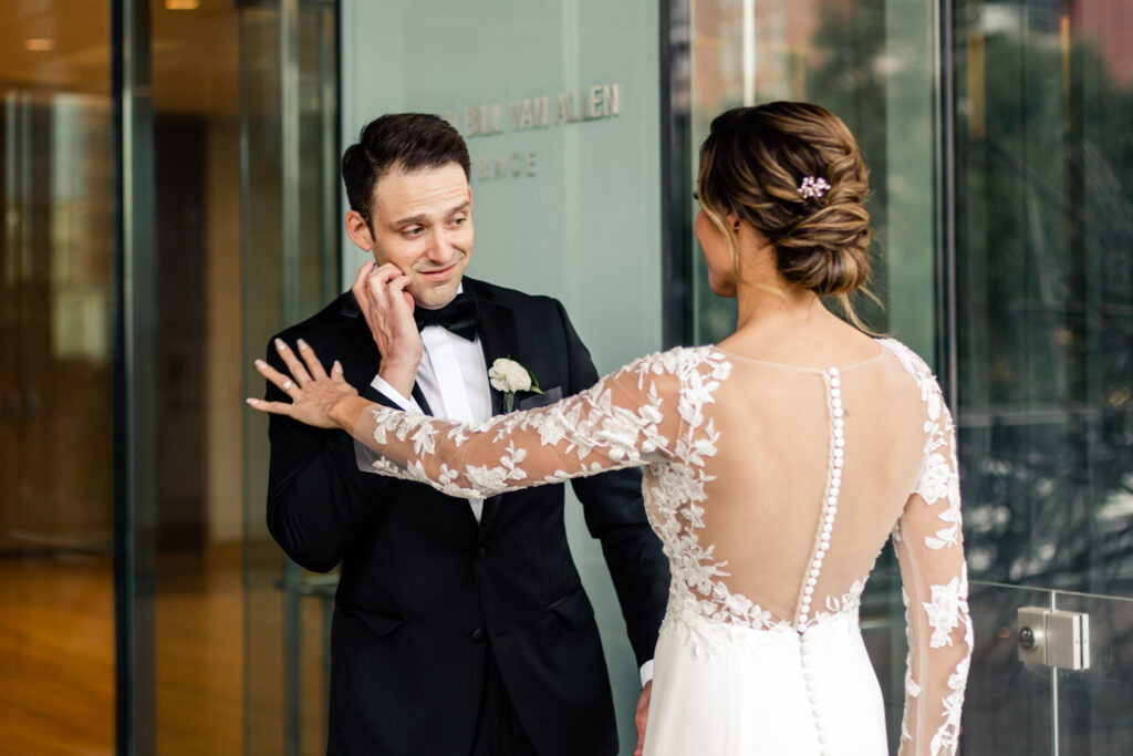 Bride, in white lace dress, seeing groom, in black suit, for the first time at the Mint Museum wedding venue in Uptown Charlotte