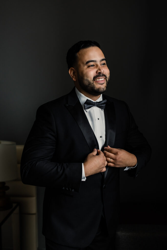 Groom, in black suit and bowtie, getting ready at The Highlawn Wedding venue in New Jersey. Photographed by Charlotte Wedding photographer.