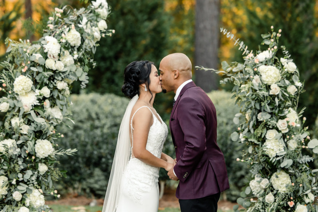 Bride and groom first kiss during ceremony at the Bradford wedding venue in Raleigh NC.