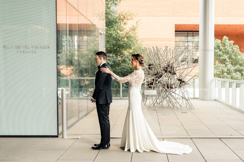 Bride, in white lace dress, seeing groom, in black suit, for the first time at the Mint Museum wedding venue in Uptown Charlotte