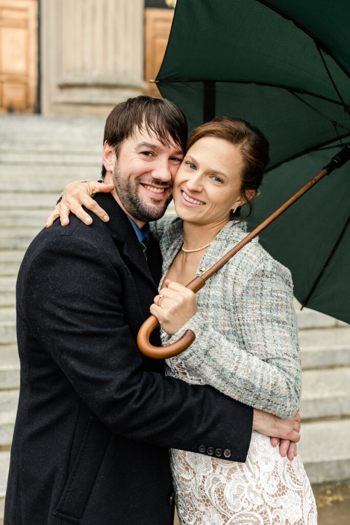 Bride and groom smiling in the rain after their courthouse elopement in Uptown Charlotte. Photographed by Stephanie Bailey Photography. 