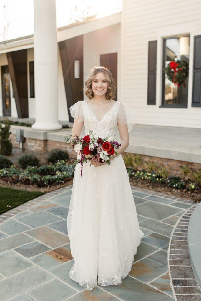 Bride, in white gown, holds red floral bouquet at 1705 East Raleigh Wedding Venue. Photographed by Charlotte Wedding Photographer, Stephanie Bailey Photography.