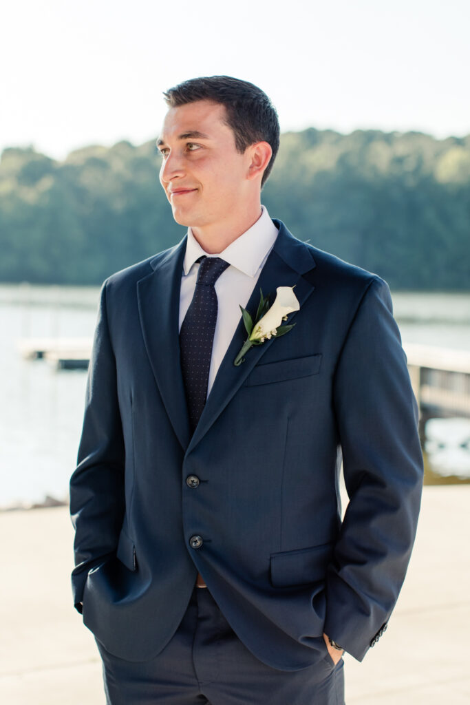 Groom with short brown hair in blue suit and tie with white flower boutonniere photographed by Charlotte Wedding Photographer