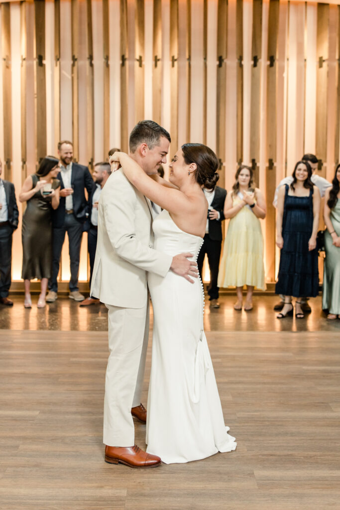 Bride, in white strapless dress, dancing with her groom, in tan suit, during reception at The Ruth wedding venue in Charlotte NC. Photographed by Charlotte Wedding Photographer.