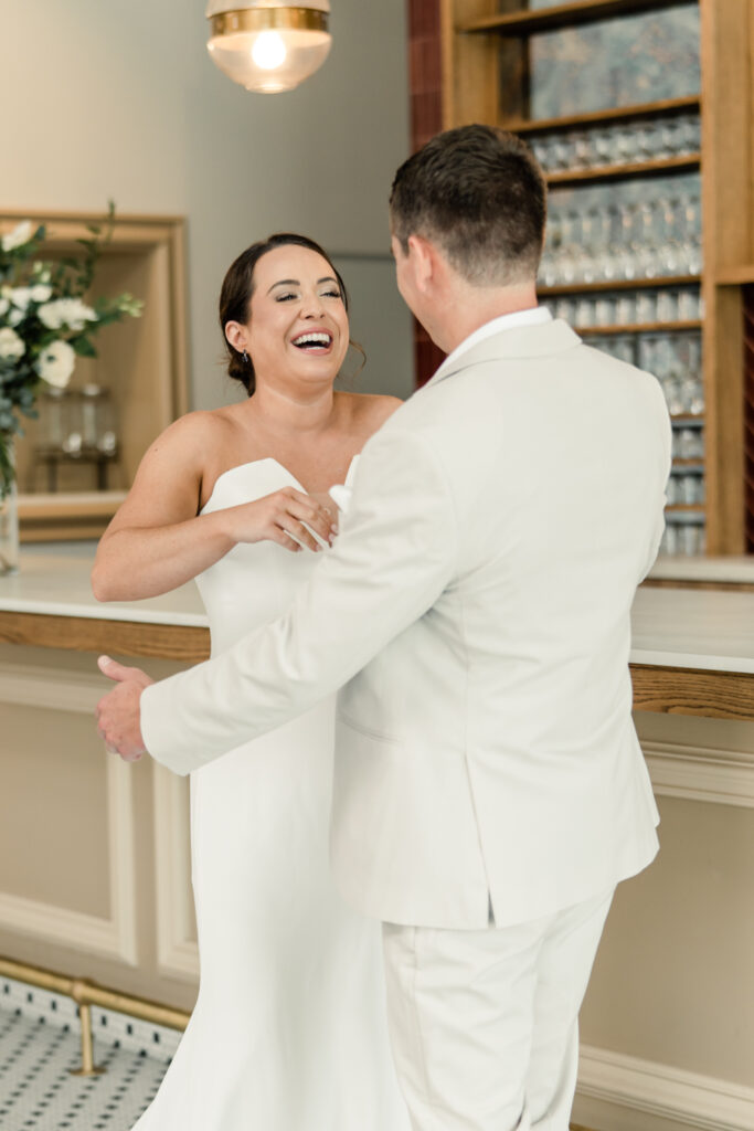 Bride, in white strapless dress, seeing her groom, in tan suit, for the first time at The Ruth wedding venue in Charlotte NC. Photographed by Charlotte Wedding Photographer.