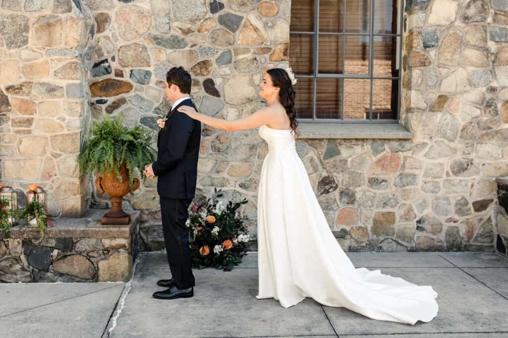 Bride with brown hair in a white strapless dress and crown seeing groom with brown hair in a navy suit for the first time at The Palmer Building Wedding Venue. Photographed by Charlotte Wedding photographer, Stephanie Bailey.